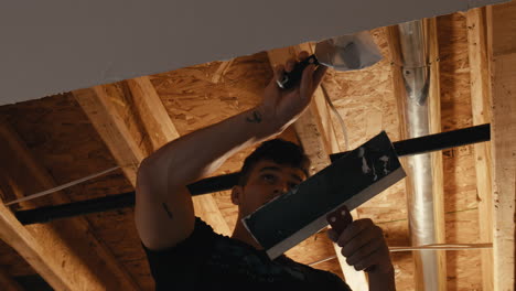 trabajador aplicando compuesto de yeso en el sitio de renovación