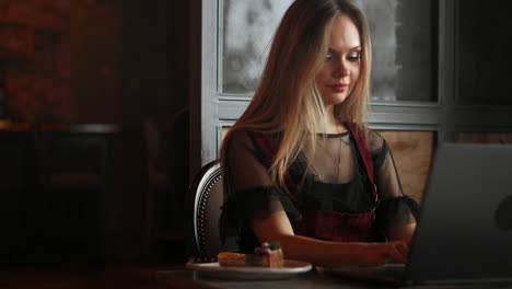 Focused-attentive-woman-in-headphones-sits-at-desk-with-laptop,-looks-at-screen,-makes-notes,-learns-foreign-language-in-internet,-online-study-course,-self-education-on-web,-consults-client-by-video