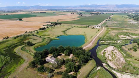 Vídeo-De-Drone-De-Un-Impresionante-Lago-Verde,-Entre-Pastizales-Y-Rodeado-De-árboles