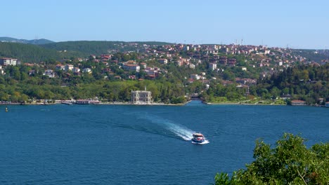 a ferry crossing the bosphorus strait, houses surrounded by lush vegetation, istanbul, turkey