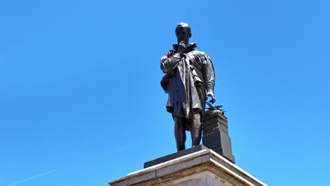drone shot descending from top of restored ambroise paré statue in laval, now installed near 11 novembre square - france