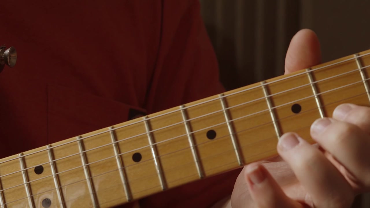Primo piano della mano di un chitarrista che suona la chitarra molto velocemente eseguendo un assolo durante le prove della band, creando nuovo materiale musicale 4K