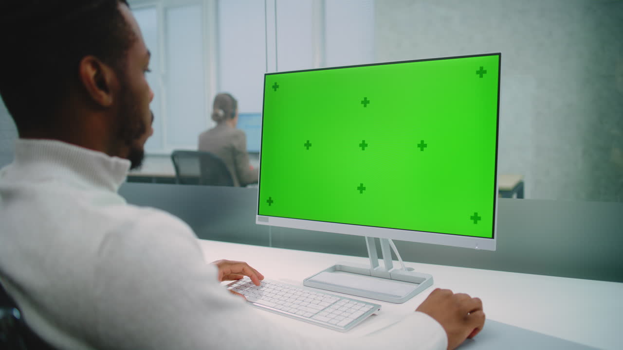 Businessperson working on computer with green screen