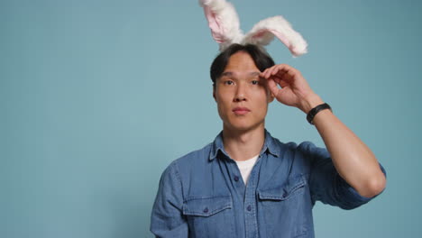 Man-In-Front-Of-Blue-Studio-Background-Having-Fun-Dressing-Up-And-Posing-For-Photo-Booth-Style-Portraits-With-Props