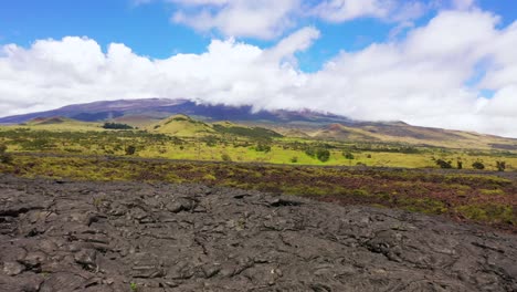 low aerial drone shot of flying over mauna kea lava field - big island hawaii
