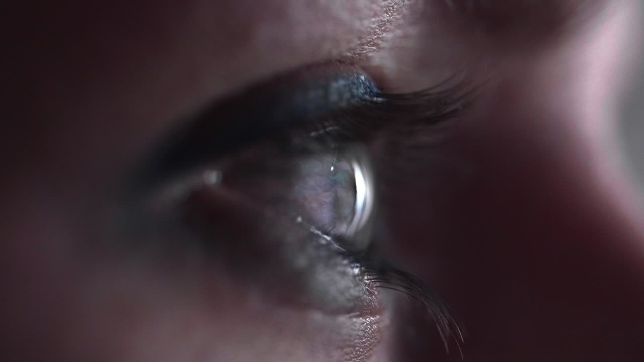 riflesso dello schermo sull'occhio blu-verde della persona nella stanza buia 22