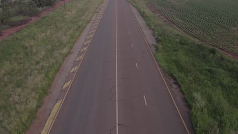 vista aérea de una carretera vacía en un paisaje rural cubierto de hierba