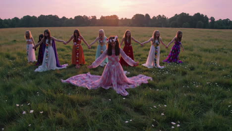 circle of girls in meadow at sunset