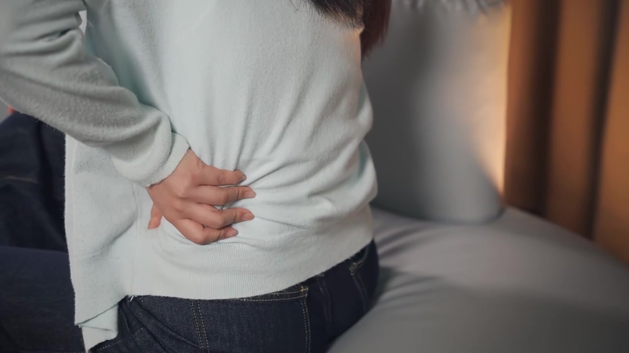 Young woman can not sleep, suffering lower back pain with glowing lumbar spine inflammation, skeletal ache muscle weakness, concept of osteoporosis, arthritis, lumbar spine issues, medicine products