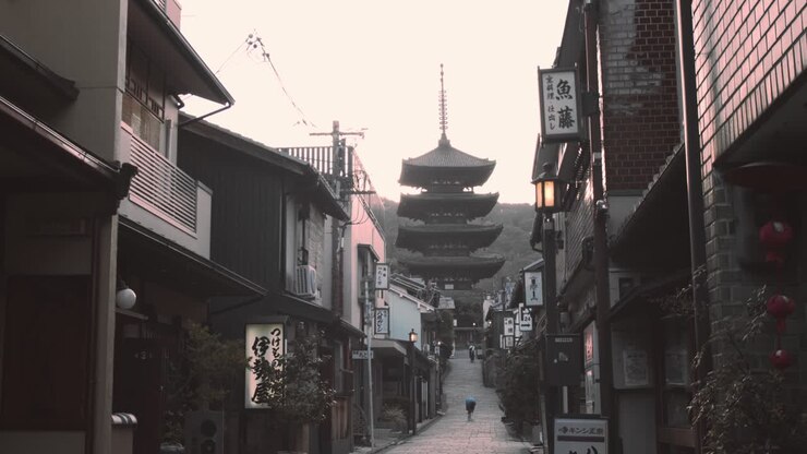 Ripresa scorrevole del sole che sorge dietro un tempio al mattino presto a Kyoto, Giappone, slow motion 4K.