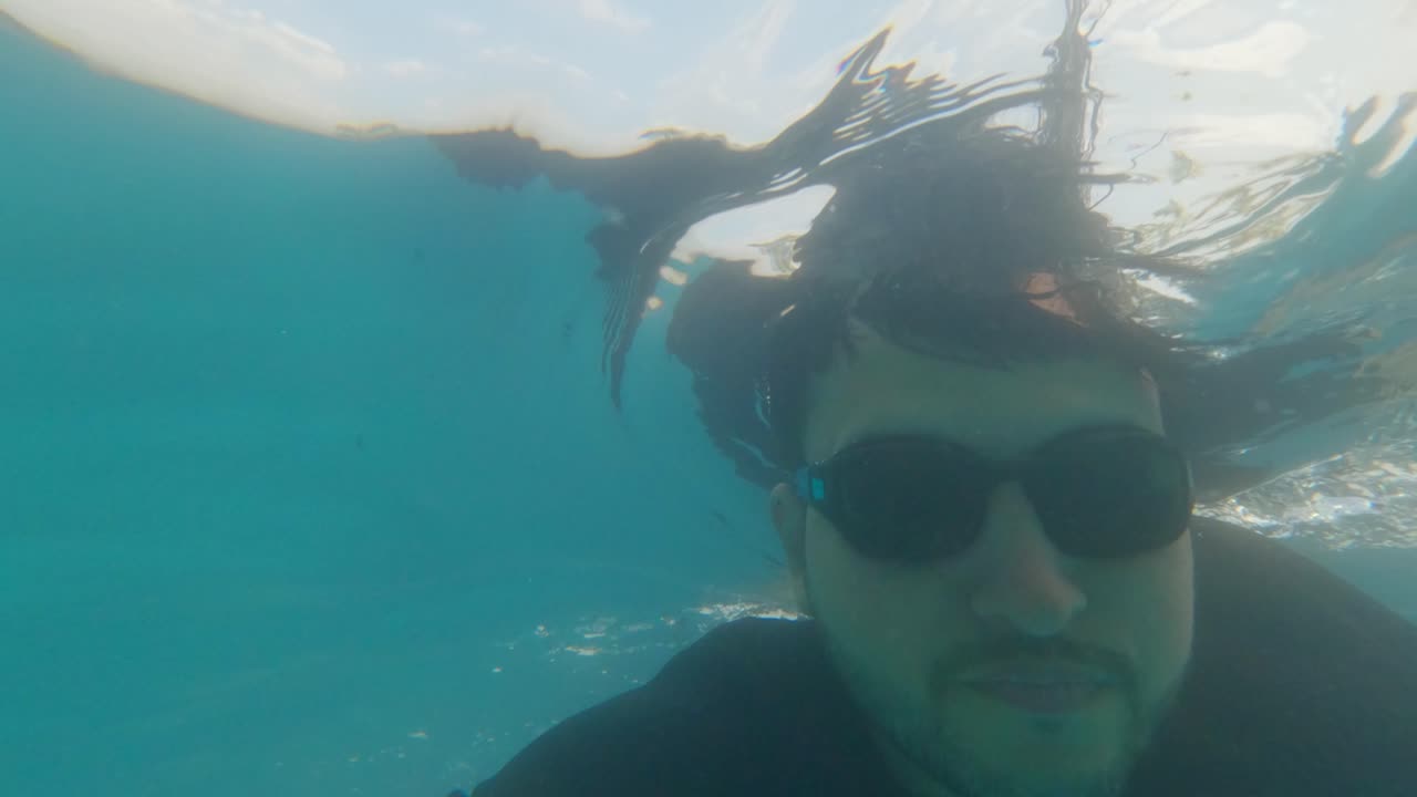 Fluid movement of athletic male swimming under water captured by action cam