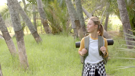 Young-Caucasian-woman-with-a-backpack-enjoys-a-sunny-day-outdoors-with-copy-space