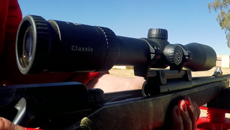 close-up-of-rifle-round-being-ejected-from-the-chamber-by-a-lady-with-red-fingernails