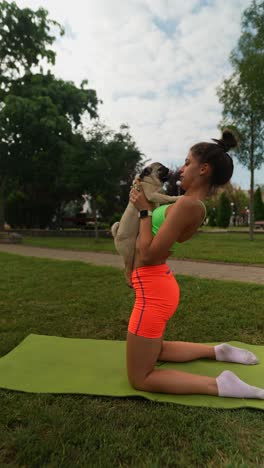mujer practicando yoga con un pug en un parque
