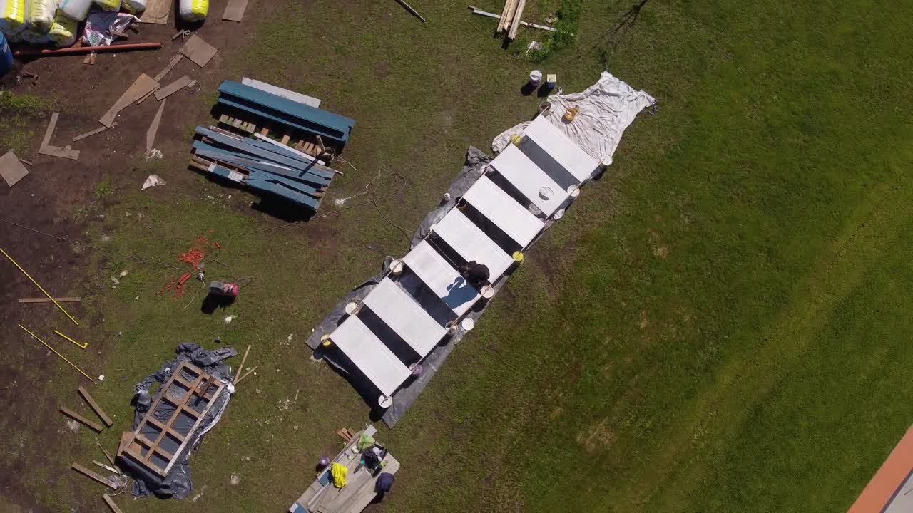 인식 할 수 없는 남자가 밖에서 줄에  문을 칠하고 있습니다.