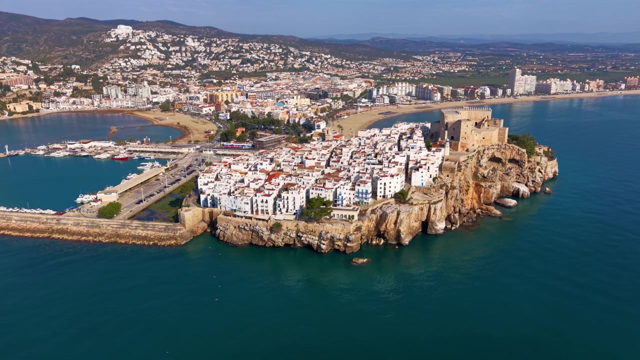 Peniscola gamle bydel beliggende på en klippefremspring, der strækker sig ud i Middelhavet, Spanien, med et middelalderligt slot, hvide bygninger, havn og sandstrand