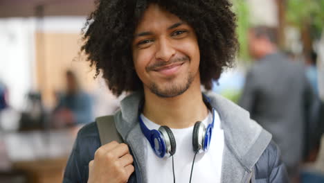 homem afro moderno sorrindo do lado de fora em uma cidade urbana