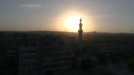 dron volando sobre una mezquita siria bajo la puesta del sol. podemos ver la ciudad de aleppo en todo el horizonte 4k