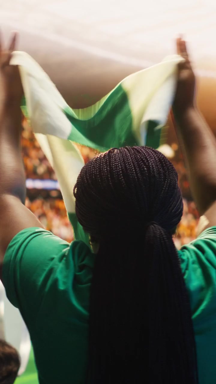 Vertical video Rear view of soccer supporters in stadium applauding players, singing together