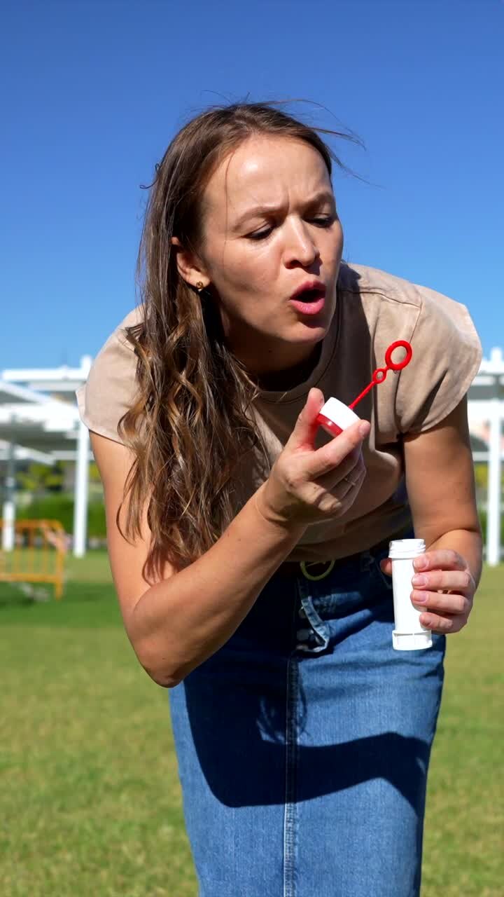 Donna che fa le bolle di sapone al parco