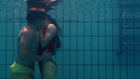 pareja romántica besándose bajo el agua en la piscina jóvenes enamorados disfrutando de un beso íntimo amantes sumergidos en el agua flotando con burbujas en una intimidad apasionada