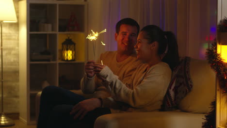 un marido alegre y su esposa jugando con fuegos artificiales