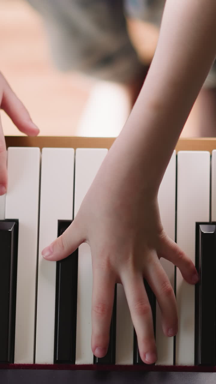 Girl musician plays composition with notes of shortened duration. Schoolgirl improves piano playing techniques in class upper view on blurred background
