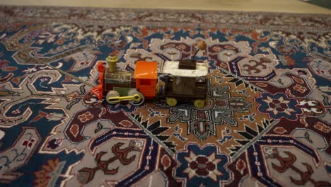 vintage toy train being pulled across a carpet - isolated close up