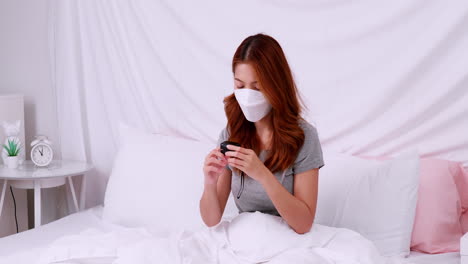 Asian-woman-with-mask-measuring-blood-oxygen-saturation-level-with-pulse-oximeter-at-home-during-the-COVID-19-pandemic-and-self-quarantine