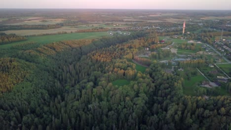 rural countryside city surrounded with dense forests - aerial pan to the left