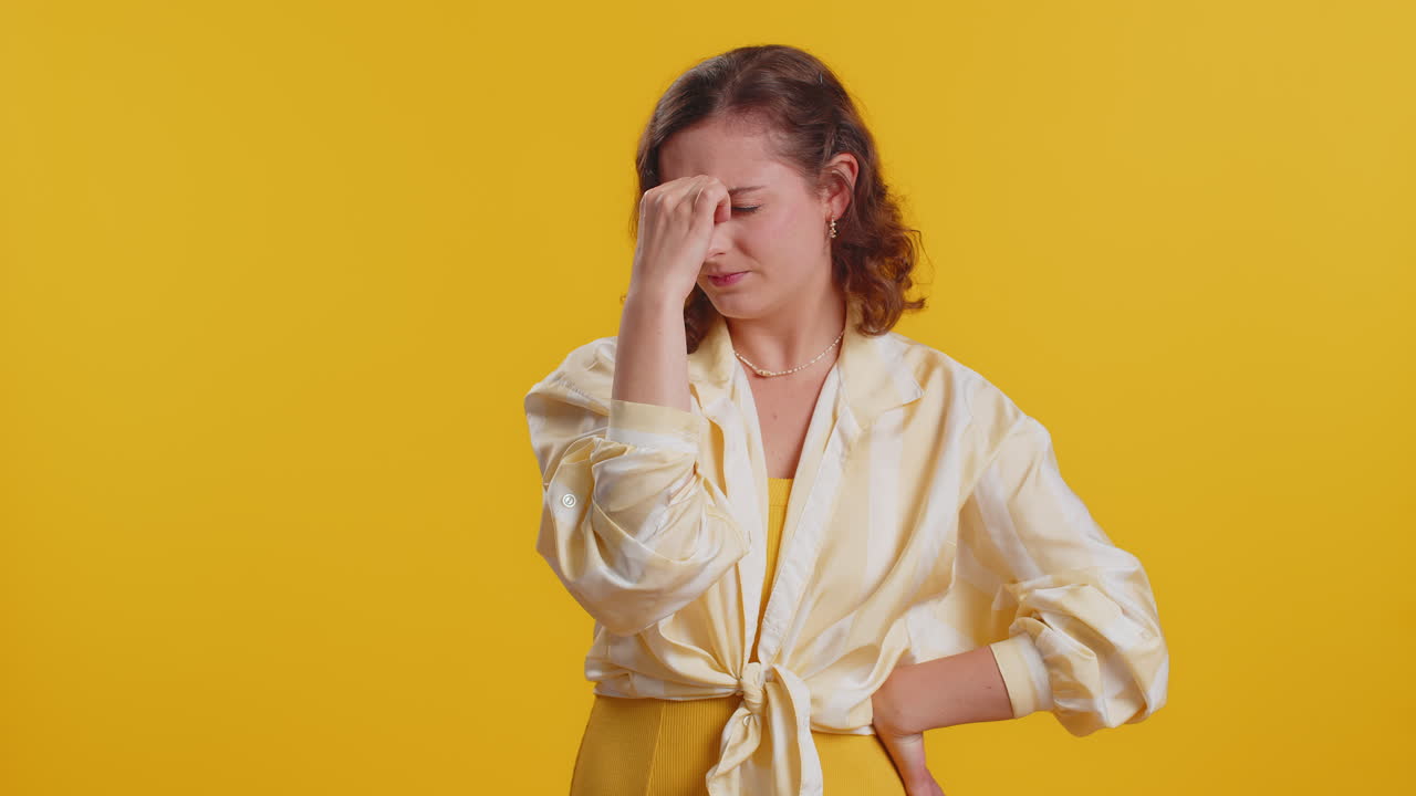 Giovane donna che massaggia le tempie per curare il problema del mal di testa che soffre di tensione e dolore da stress migaine