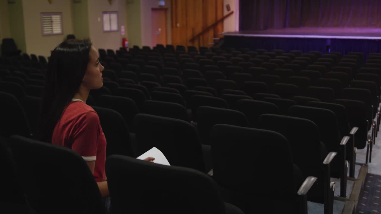 Caucasian high school teenage girl in the auditorium preparing for a performance