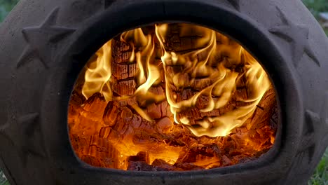 SLO-MO:-Burning-embers-in-a-terra-cotta-chimenea-during-late-evening