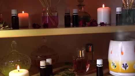 perfume making room with lots of candles flasks and glasses with colored liquids, near a steamer with steam coming out, and dust flying around