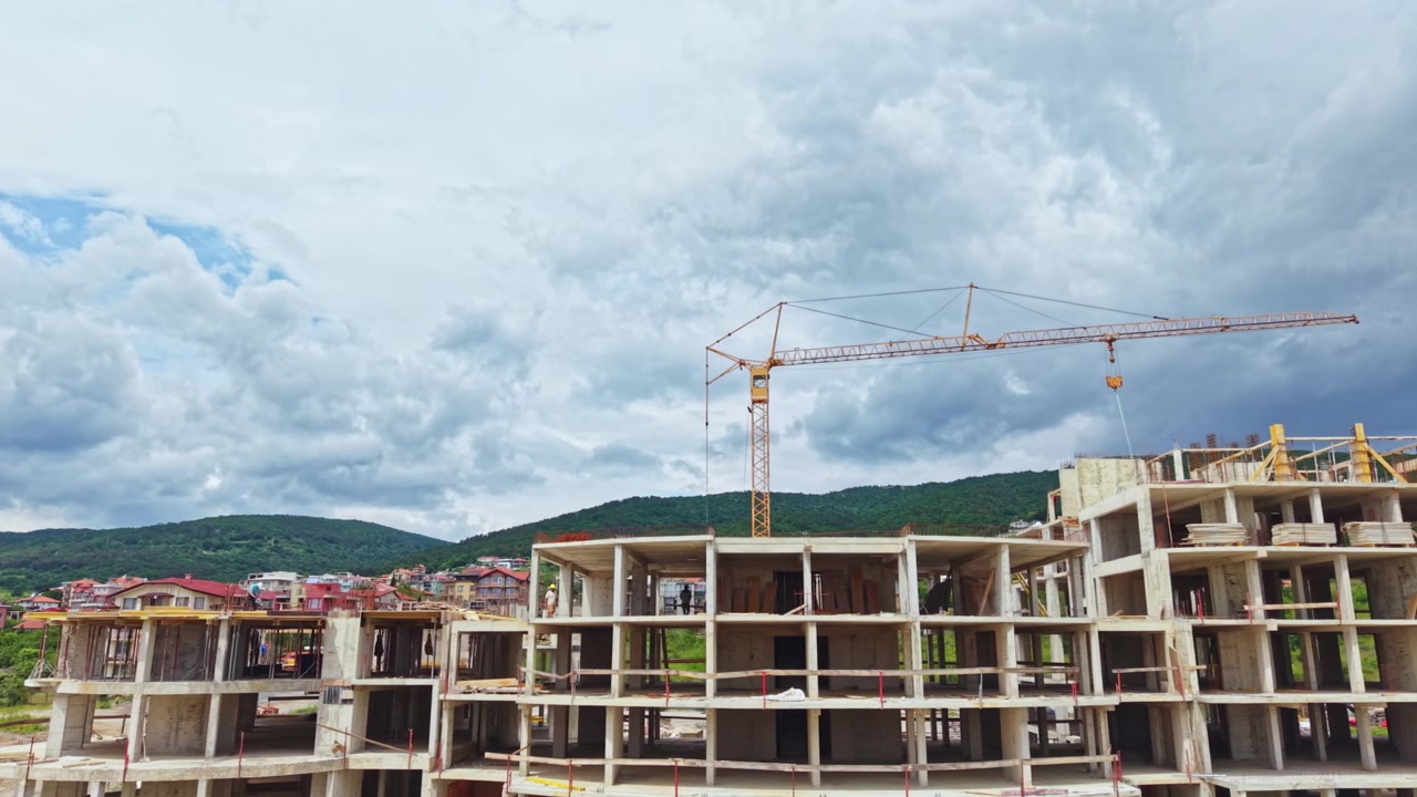Cielo tempestoso su un cantiere edile. Il maltempo incornicia l'attività di costruzione in corso. Vento impetuoso e nuvole temporalesche creano un'atmosfera su un progetto di costruzione resiliente.