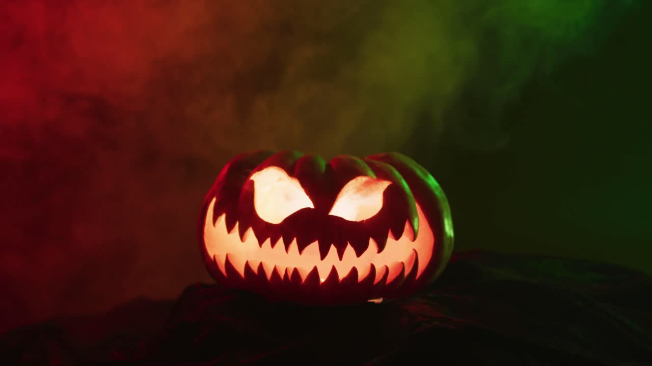 video de calabaza tallada de halloween con humo y luz verde y roja sobre fondo negro