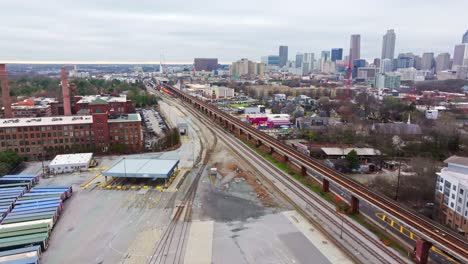 Instalación-De-CSX-Vacía-Cerca-De-Los-Lofts-De-La-Fábrica-De-Algodón-Fulton-De-Colchtown-Con-El-Horizonte-Del-Centro-De-Atlanta-Y-Rascacielos-Al-Fondo,-EE.UU.