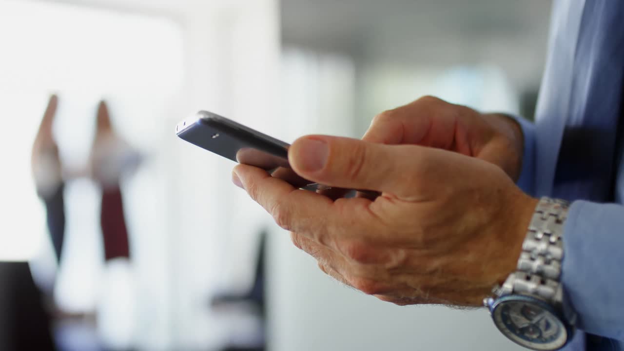 Empresario usando teléfono móvil en la oficina 4k