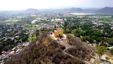 orbital drone shot of church on top of hill in atlixco mexico