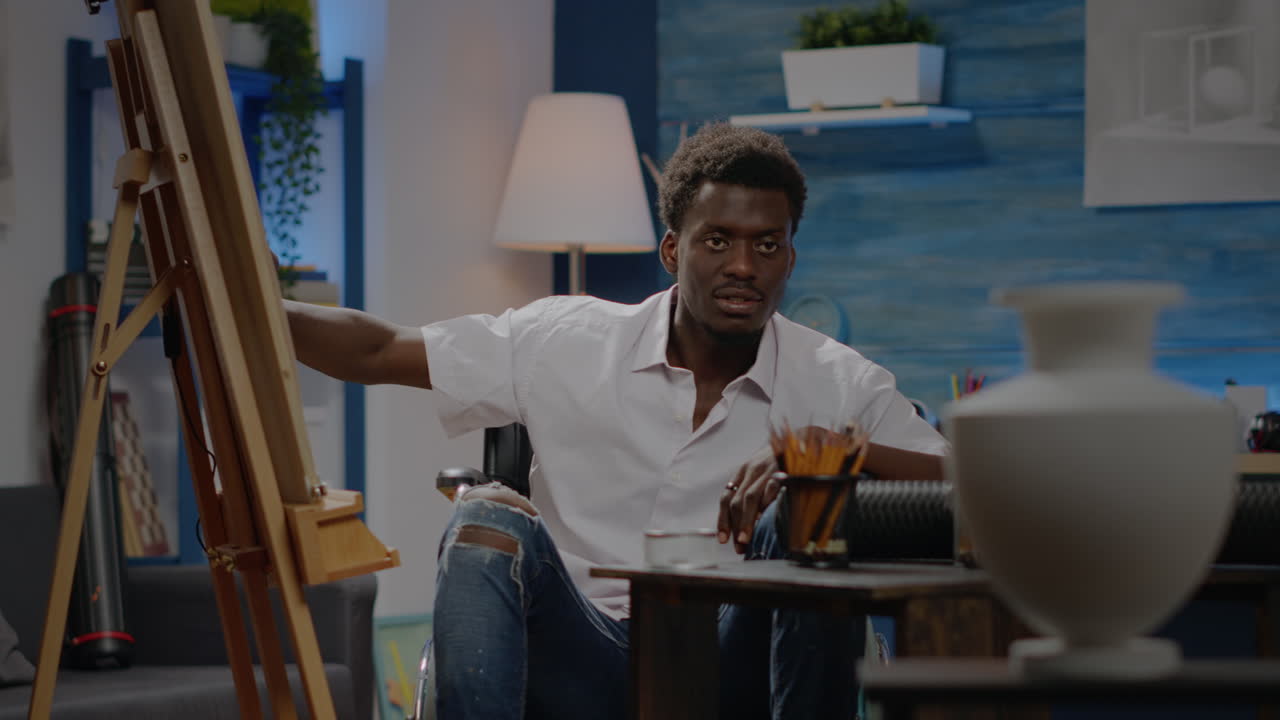 Disabled black artist looking at vase design for drawing inspiration