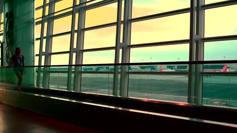 a woman is riding on the travelator at the airport