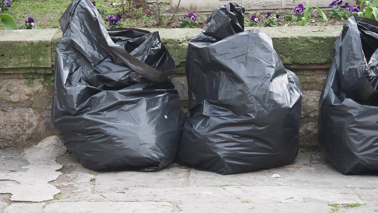 Garbage Bags Placed Along a Stone Wall