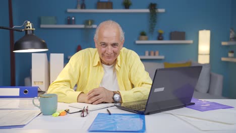 Home office worker old man nods to the camera.