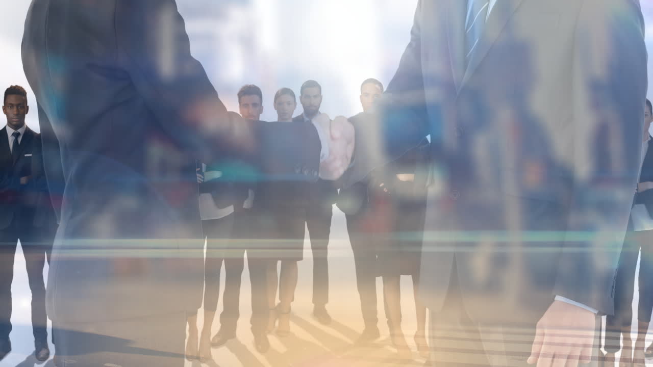 Animation of businessman and businesswoman shaking hands over group of business people