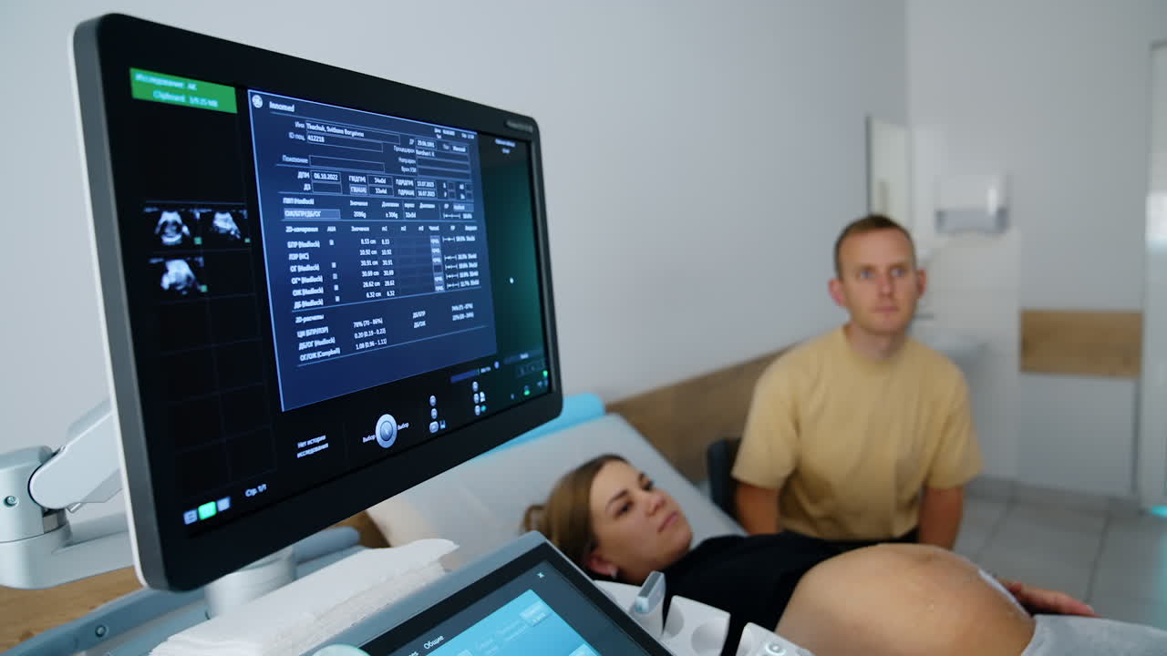 Pregnant woman undergoing ultrasound examination with partner