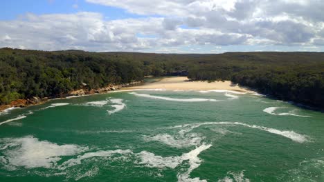 drone flying over wattamolla beach at royal national park in new south wales, australia - aerial shot