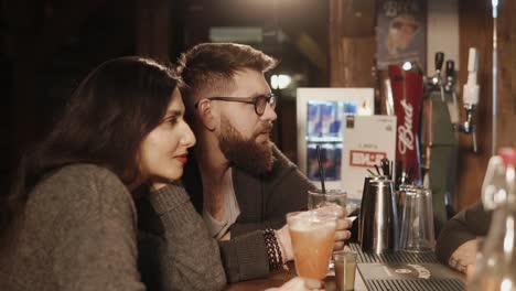 couple enjoying drinks at a bar at night