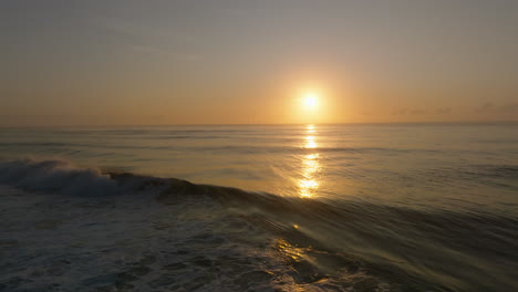 Backwards-slowmo-shot-of-ocean-wave-breaking-against-sunset-backdrop-in-Australia