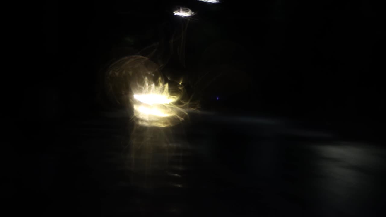 la luz blanca se refleja abstractamente en gotas en el parabrisas.