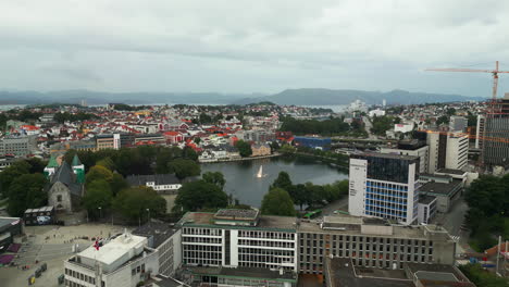 aerial dolly toward breiavatnet lake with fountain in stavanger city, norway